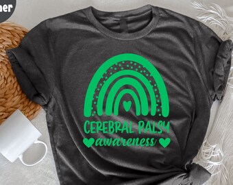 May include: A dark grey heather t-shirt with a green rainbow design and the text "Cerebral Palsy awareness" with green hearts.