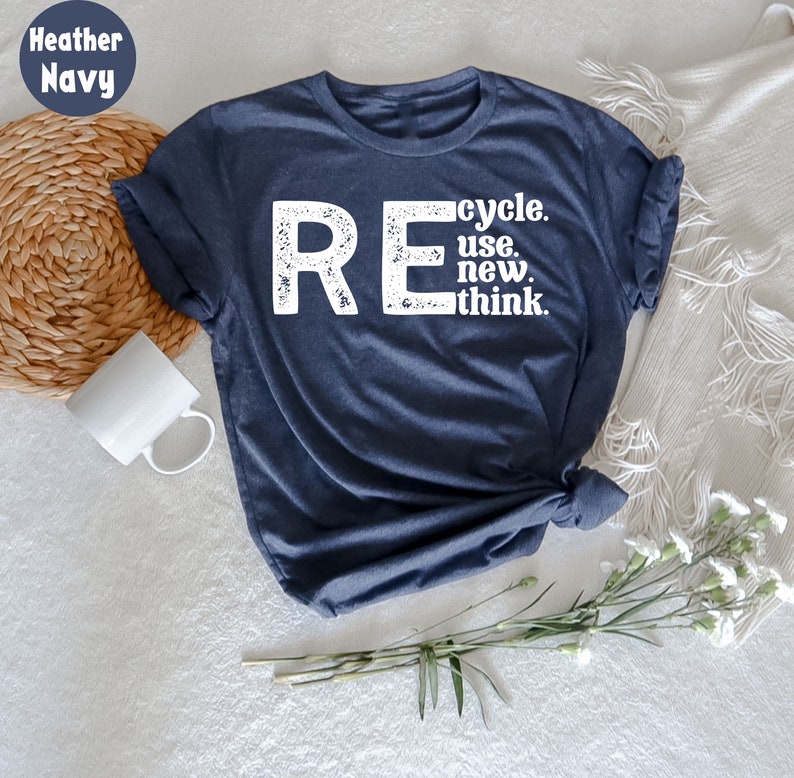 May include: A heather navy blue t-shirt with a white distressed graphic that reads "REcycle. use. new. think."