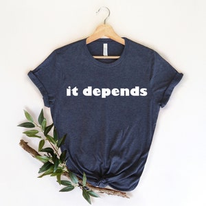 Pode incluir: Uma camiseta azul escura com o texto "it depends" impresso em branco na frente.