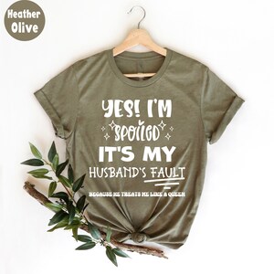 May include: A green t-shirt with the text "YES! I'M SPOILED IT'S MY HUSBAND'S FAULT BECAUSE HE TREATS ME LIKE A QUEEN" in white.