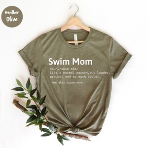 Może przedstawiać: Zielony T-shirt z tekstem "Swim Mom" zdefiniowanym jako "Jak normalna osoba, ale głośniejsza, bardziej dumna i o wiele fajniejsza. Zobacz także: super-mama"