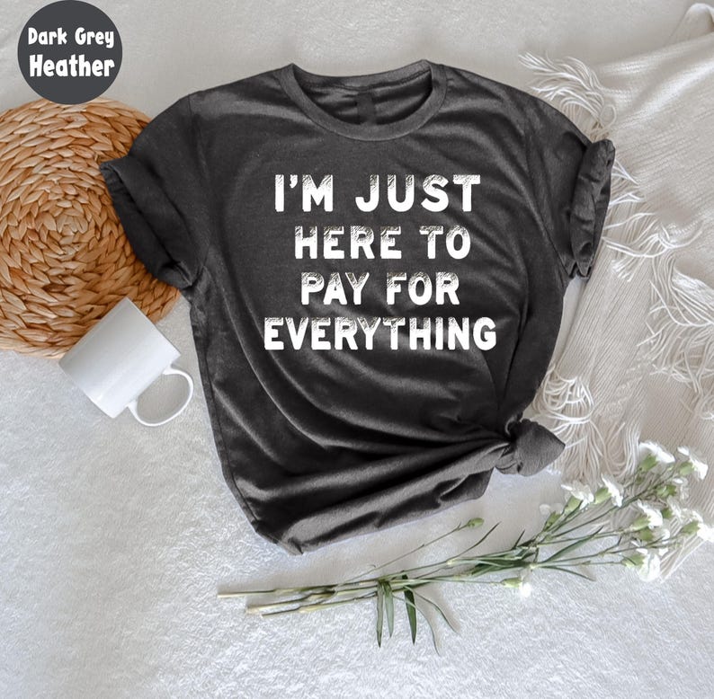 This "I'm Just Here To Pay For Everything" t-shirt is the perfect shirt for parents with a sense of humor. Whether you're a mom or dad, this tee captures the funny side of parenting with a playful twist. Made from soft, breathable cotton, this comfortable shirt is great for casual wear, family outings, or just relaxing at home. A perfect gift for parents who enjoy a good laugh while managing the family responsibilities.