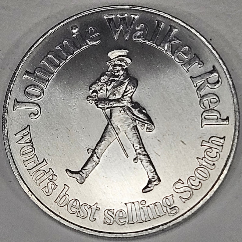 May include: Silver coin featuring a walking man with a cane and the text "Johnnie Walker Red" and "World's best selling Scotch".