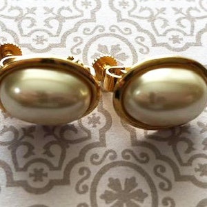 Puede incluir: Un par de pendientes de clip de tono dorado con acentos de perlas falsas.