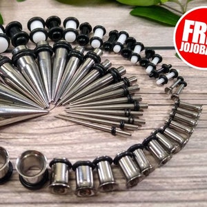 May include: A set of 20 stainless steel ear gauges and plugs, including a variety of sizes and styles, including tapers and tunnels. The set also includes a few pairs of black and white acrylic plugs. Free jojoba oil is included.