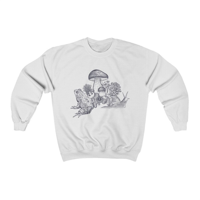 May include: A white sweatshirt with a blue and white illustration of a frog, snail, and mushrooms. The illustration is centered on the sweatshirt.