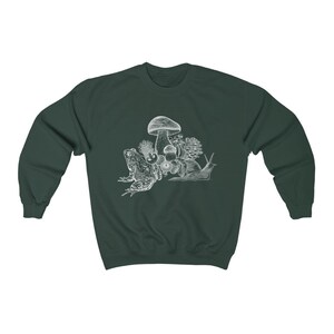 May include: A dark green sweatshirt with a white illustration of a frog, snail, and mushrooms.
