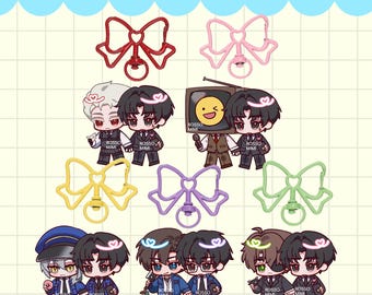 May include: A collection of GDGS/GSGW keychain charms by Rosso Mimi featuring various chibi-style characters in suits and uniforms, paired with colorful bow-shaped metal clasps in red, pink, yellow, purple, and green on a grid background.
