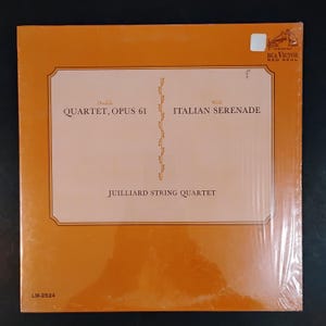May include: An orange vinyl record album featuring the Juilliard String Quartet. The album cover has text that reads "Dvorak QUARTET, OPUS 61" and "Wolf ITALIAN SERENADE". The RCA Victor Red Seal logo is in the upper right corner.