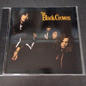 May include: A music CD case featuring the album cover for The Black Crowes. The cover art displays a dark, moody photograph of band members in black clothing against a deep blue and black background, with the band name printed in yellow text.