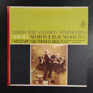 May include: A square vinyl record cover featuring a yellow top section with the text HAYDN: THE SALOMON SYMPHONIES ALBUM 4-NO. 99 IN E FLAT-NO. 100 IN G (MILITARY) SIR THOMAS BEECHAM ROYAL PHILHARMONIC ORCHESTRA and an oil painting of an orchestra.