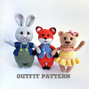 May include: Three crocheted stuffed animals: a gray bunny wearing blue overalls, a red fox wearing a blue vest, and a brown bear wearing a yellow dress with pink trim.  The animals are all standing on a white background.  OUTFIT PATTERN is written below the animals.