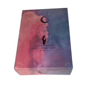Könnte beinhalten: Eine rechteckige Tarot-Kartenschachtel mit einem wolkenartigen Farbverlauf in Pink und Blau. Die Vorderseite zeigt eine schwarze Strichzeichnung eines Halbmonds, eines Auges in einem Dreieck und einer Hand über Schmetterlingsflügeln. Der Text lautet THE BLACK QUEER TAROT By Kendrick Daye.