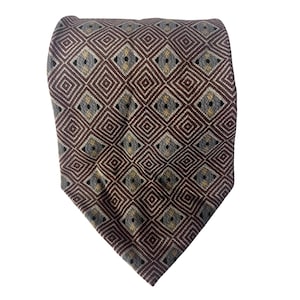 May include: A brown necktie featuring a repeating geometric diamond pattern in shades of brown, grey, and yellow. The tie is made of a textured fabric and is displayed against a white background.