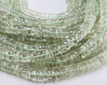 May include: A strand of light green, faceted, glass beads. The beads are round and have a slightly irregular shape. The beads are strung on a clear thread.
