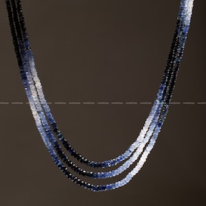 Puede incluir: Un collar de múltiples hilos hecho de cuentas de zafiro graduadas. Las cuentas son facetadas y varían en color de azul oscuro a azul claro. El collar es un hermoso ejemplo de artesanía fina.