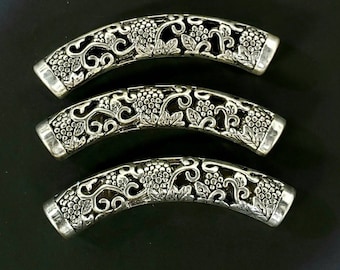 May include: Three silver-toned metal bead caps with a decorative grapevine design. The caps are curved and have a hollow center.