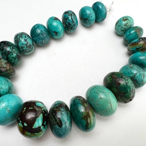 May include: A strand of turquoise beads, each bead is a different shade of blue and green with brown marbling. The beads are oval shaped and have a smooth, polished finish.