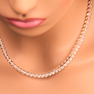 May include: A clear crystal beaded necklace on a mannequin.