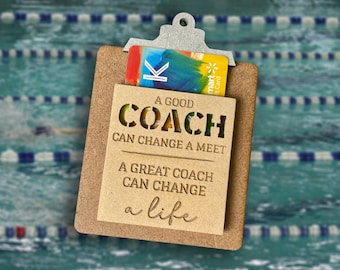May include: A wooden clipboard with a gift card and the text "A good coach can change a meet. A great coach can change a life."
