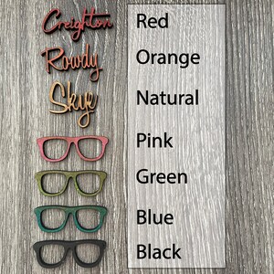 May include: Wooden glasses with different color options: red, orange, natural, pink, green, blue, and black. The text "Color Options" is below the glasses.