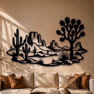 Può includere: Un'opera d'arte da parete in metallo nero che presenta la sagoma di un paesaggio desertico con un cactus saguaro, un albero di Giosuè e formazioni rocciose. Il design è piatto e tagliato nel metallo, mostrando una scena desertica.