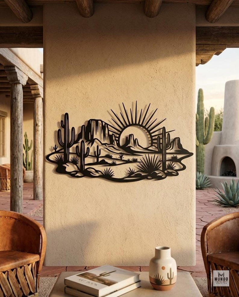 A black metal saguaro cactus landscape wall art piece is mounted on an exterior stucco wall of a patio.