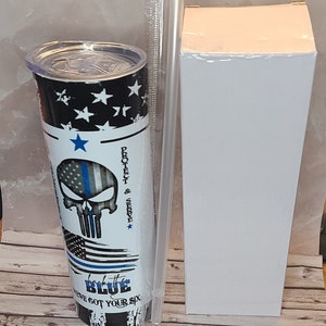 Può includere: Un bicchiere bianco e blu con un'immagine di teschio e il testo "Protect & Serve" e "Back the Blue We've Got Your Six".