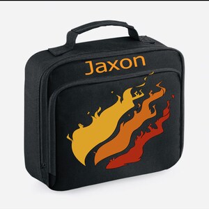 May include: Black lunch bag with a personalized name "Jaxon" in orange text and a stylized orange, yellow, and red flame design.