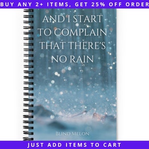 Puede incluir: Una libreta de espiral azul con una imagen borrosa de gotas de lluvia sobre un fondo azul. El texto "AND I START TO COMPLAIN THAT THERE'S NO RAIN" está impreso en blanco en la portada. El texto "BLIND MELON" está impreso en blanco en la parte inferior de la portada.