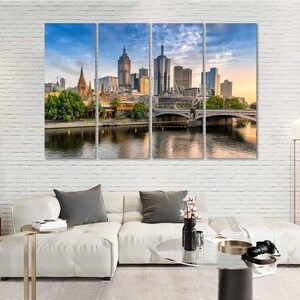 May include: A panoramic view of the Melbourne skyline with modern skyscrapers and a bridge over a river. The city is bathed in warm sunlight, creating a vibrant and energetic atmosphere.