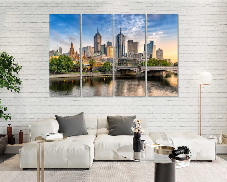 May include: A panoramic view of the Melbourne skyline with modern skyscrapers and a bridge over a river. The city is bathed in warm sunlight, creating a vibrant and energetic atmosphere.