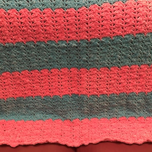 May include: A crocheted blanket with alternating stripes of pink and teal.