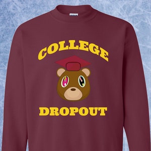 May include: Burgundy sweatshirt with a yellow graphic of a brown bear wearing a graduation cap. The text "COLLEGE DROPOUT" is printed in yellow above and below the bear.