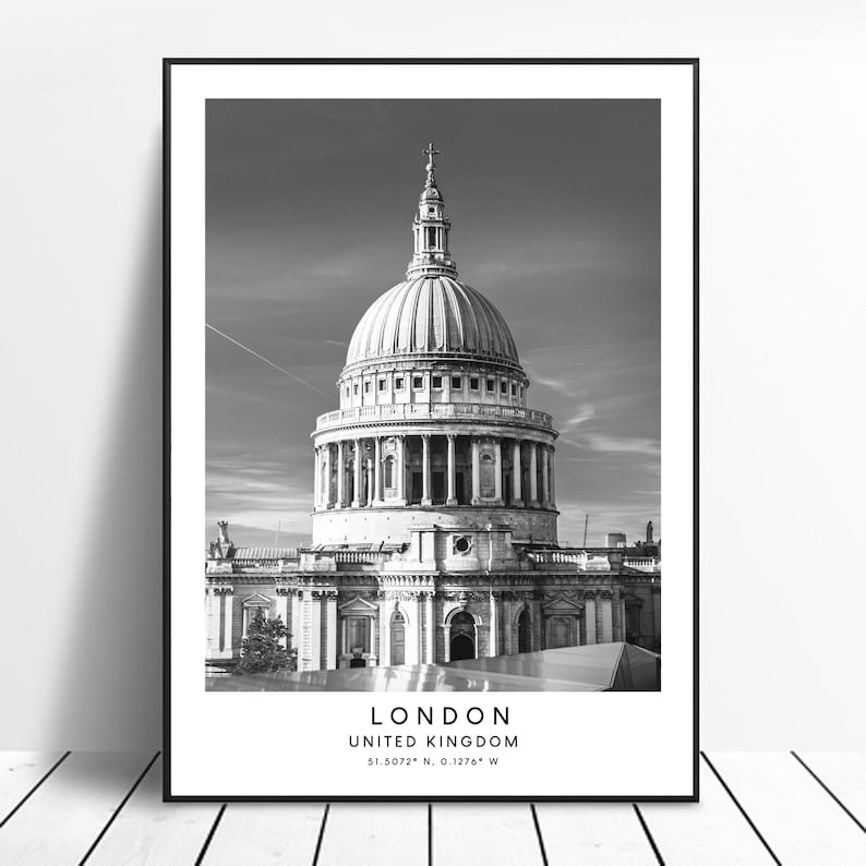May include: A black and white photograph of St Paul's Cathedral in London, England. The photo shows the dome and facade of the cathedral. The text "LONDON, UNITED KINGDOM, 51.5072&deg; N, 0.1276&deg; W" is printed below the image.