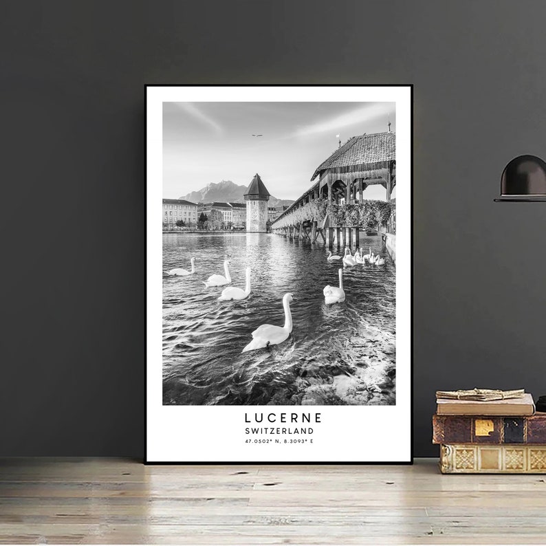 Peut inclure: Impression encadr&eacute;e en noir et blanc de Lucerne, Suisse. L'image pr&eacute;sente des cygnes nageant dans un lac, un pont en bois et une tour. Le texte "LUCERNE SWITZERLAND" est imprim&eacute; en bas, avec les coordonn&eacute;es.