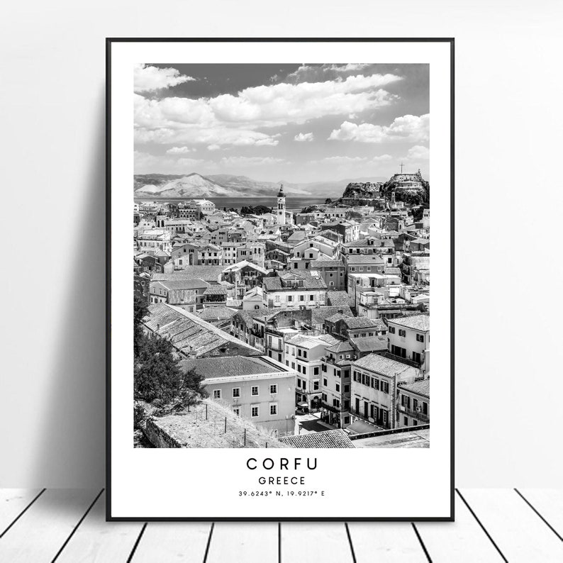 May include: A black and white photograph of the city of Corfu, Greece. The photo shows a cityscape with many buildings and a body of water in the distance. The text "CORFU GREECE 39.6243&deg; N, 19.0217&deg; E" is at the bottom of the photo.