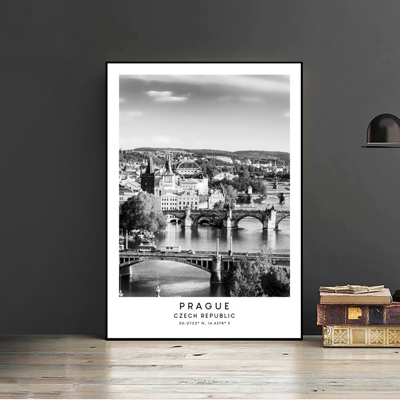 May include: Black and white photograph of Prague, Czech Republic, with a view of the Charles Bridge and the city skyline. The text "Prague, Czech Republic, 50.0755&deg; N, 14.4378&deg; E" is printed at the bottom of the image.
