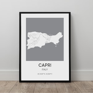Könnte beinhalten: Ein gerahmter Druck mit einer Karte von Capri, Italien, in Weiß auf grauem Hintergrund. Die Karte zeigt die Form und Straßen der Insel. Der Text "CAPRI ITALY" und Koordinaten sind darunter. Der Rahmen ist schwarz.