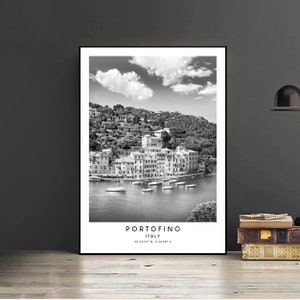 May include: Black and white photograph of the Italian village of Portofino, with colorful buildings on a hillside overlooking a harbor with boats. The text "Portofino, Italy 44.3032&deg; N, 9.2068&deg; E" is at the bottom of the image.