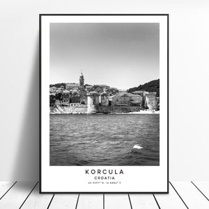 May include: A black and white photograph of the town of Korcula, Croatia. The town is situated on a peninsula and is surrounded by water. The photo is taken from the water, looking towards the town. The text "KORCULA CROATIA 42.0297° N, 16.8880° E" is printed at the bottom of the photo.