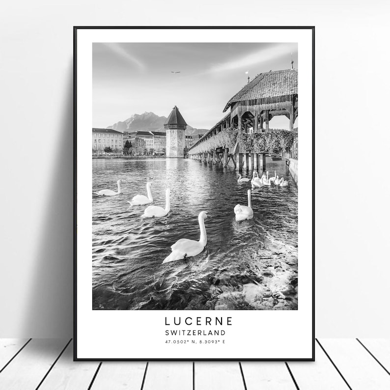 Peut inclure: Impression encadr&eacute;e en noir et blanc de Lucerne, Suisse. L'image montre des cygnes sur une rivi&egrave;re, un pont en bois et des b&acirc;timents. Le texte "LUCERNE SUISSE" et les coordonn&eacute;es sont imprim&eacute;s en bas.