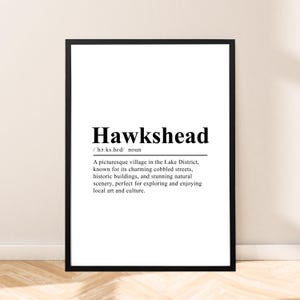 May include: Black and white printable art print with the word "Hawkshead" in bold text and a definition of the word. The definition describes Hawkshead as a picturesque village in the Lake District, known for its charming cobbled streets, historic buildings, and stunning natural scenery.
