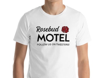 May include: White t-shirt with black text that reads "Rosebud Motel" with a red rose graphic and the text "Follow us on Tweeters!"
