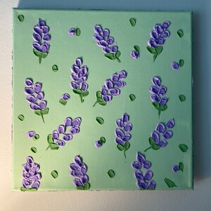 May include: A green canvas painting with a repeating pattern of purple flowers. The flowers are painted in a textured style, giving the painting a three-dimensional look.