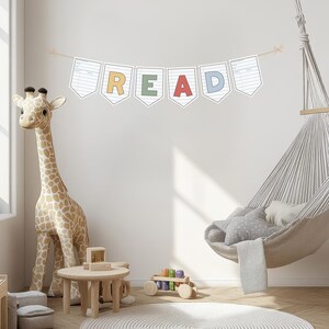 Puede incluir: Una escena de habitaci&oacute;n infantil con un gran juguete de jirafa, una peque&ntilde;a mesa de madera y una pancarta con la palabra "READ" en letras coloridas. Tambi&eacute;n se ven una silla colgante y un coche de juguete de madera.