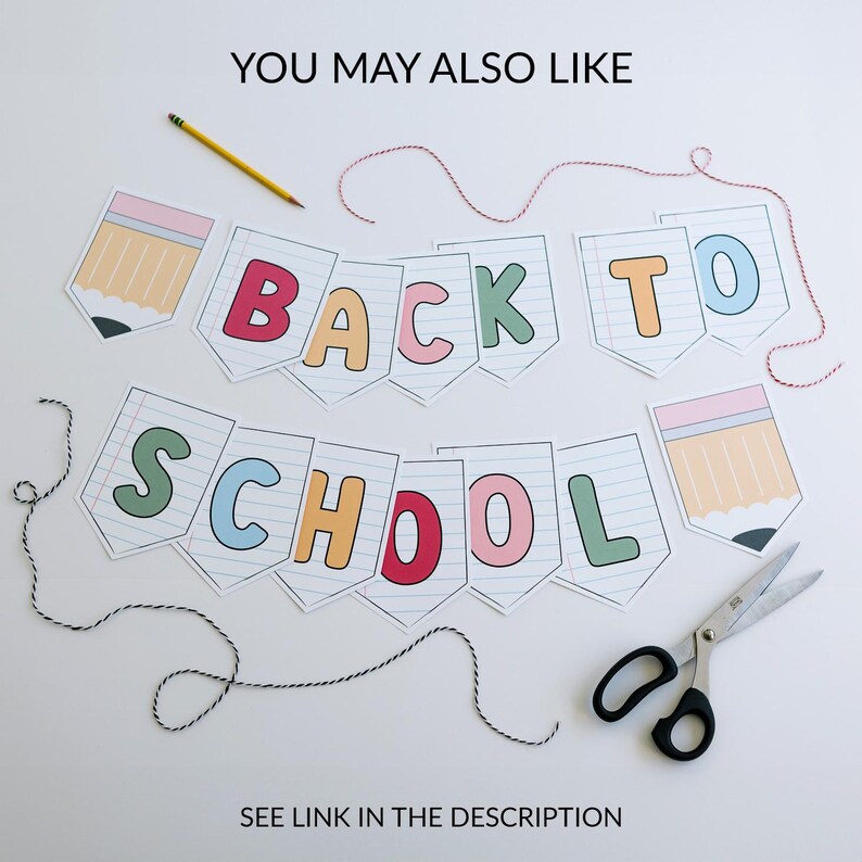 Puede incluir: Una pancarta de "Back to School" con letras coloridas e ilustraciones de l&aacute;pices. La pancarta est&aacute; hecha de papel y est&aacute; ensartada con hilo rojo y blanco. Tambi&eacute;n se incluyen un l&aacute;piz amarillo y unas tijeras.