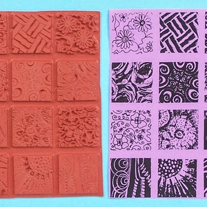 May include: A red rubber stamp with 12 square patterns of various textures and designs. Next to it is a sheet with the stamped impressions in black ink on a lavender background. The designs include floral, geometric, and abstract patterns.