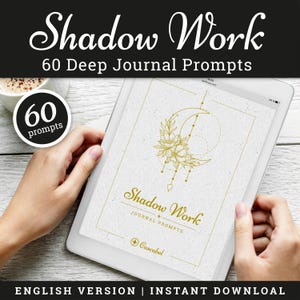 Puede incluir: Una tableta digital que muestra una portada de diario con las palabras "Shadow Work" y "60 Deep Journal Prompts". La portada presenta un diseño floral dorado y de media luna. El texto "English Version | Instant Download" está en la parte inferior.