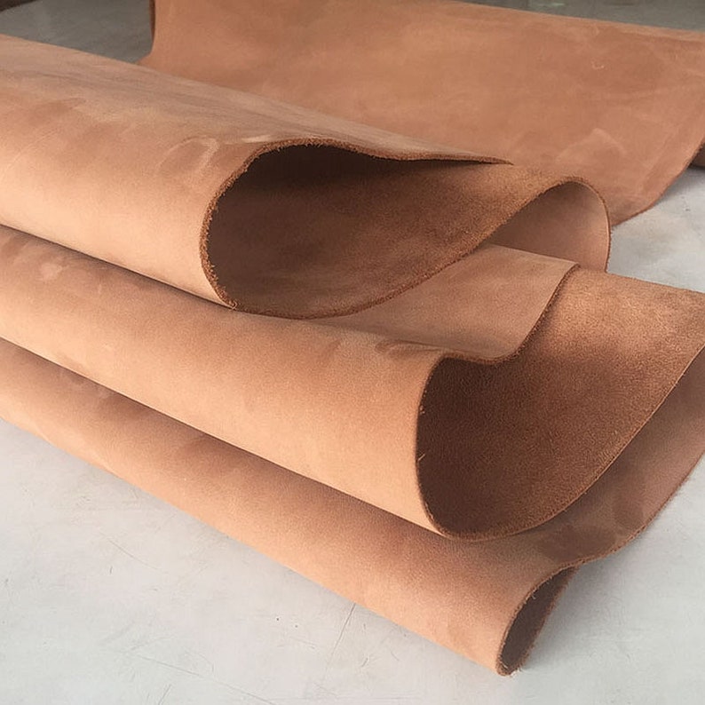 May include: A stack of brown leather hides, folded and showing the soft, suede-like texture.